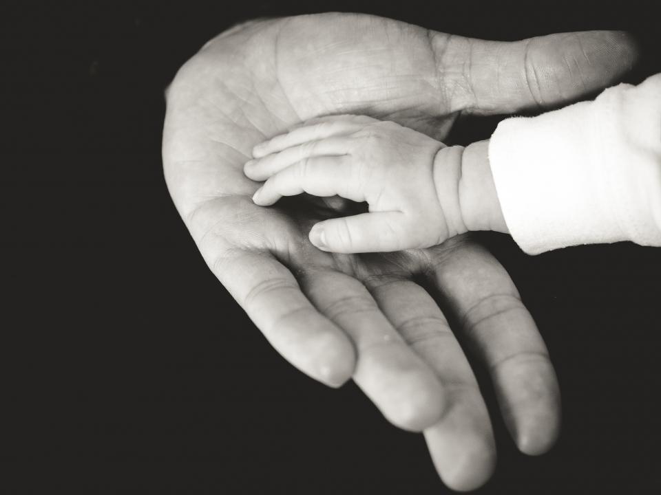 Tiny baby hands representing gifts for new parents